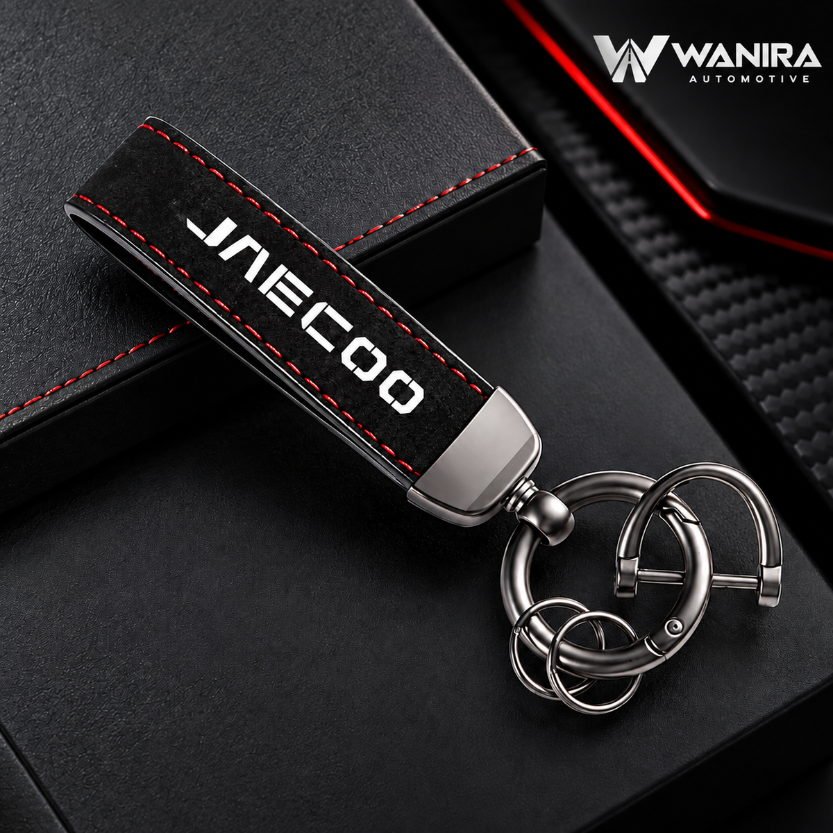 Black suede-style keychain with red stitching and WANIRA Automotive branding